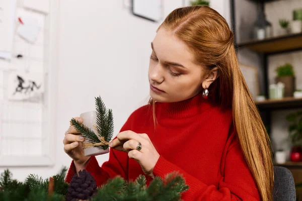 Молода жінка зосереджується на прикрасі природними елементами в теплому, запрошуючи простір вдома. — стокове фото