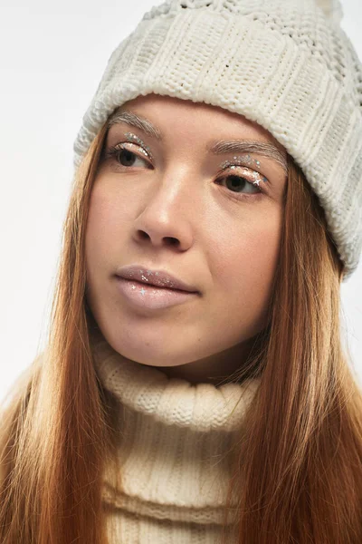 A young redhead poses confidently, showcasing cozy winter fashion in a bright setting. — Stock Photo