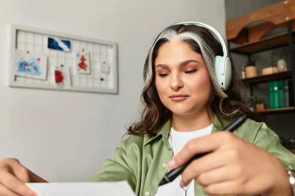 Жінка з білою ліжечкою фокусується на своїй роботі, сидячи в затишній квартирі. — стокове фото