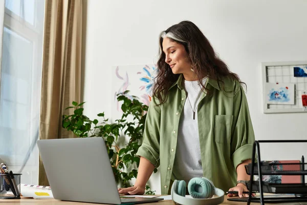 Una donna con ciuffo bianco e occhi azzurri si impegna con il suo computer portatile in un'atmosfera accogliente casa. — Foto stock