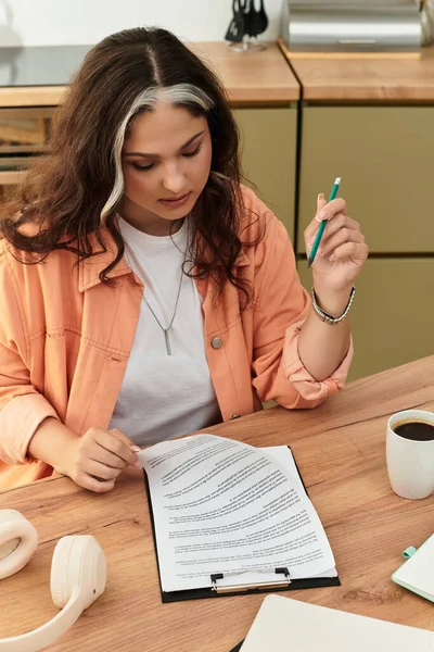 У стильній квартирі жінка з білим передпокої уважно відгукується про свою роботу під час сидіння. — стокове фото