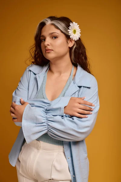 Young woman poses confidently in a studio, highlighting her distinct features and fashion. — Stock Photo