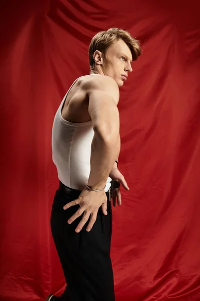 Впевнений молодий чоловік демонструє сучасну мужність в обстановці студії. — стокове фото