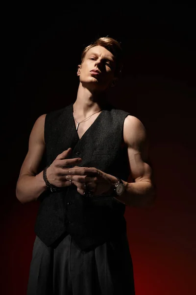 Красивий молодий чоловік втілює сучасну мужність, випромінюючи впевненість під драматичним освітленням. — стокове фото