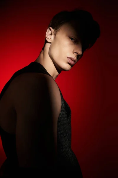 A young man stands confidently, highlighted by dramatic lighting that showcases his style. — Stock Photo