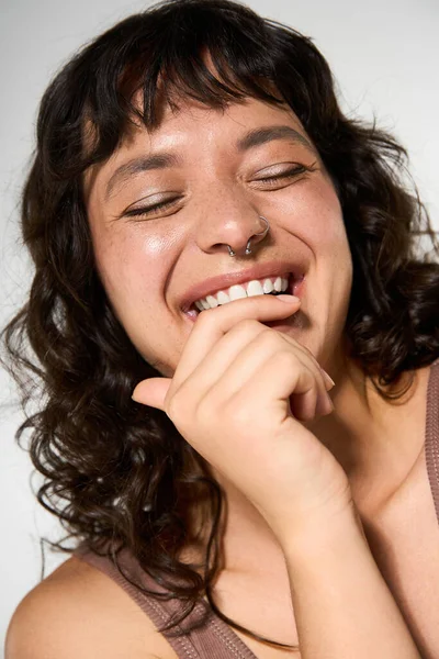 Щаслива, стильна молода жінка тепло посміхається, випромінюючи впевненість і радість. — стокове фото