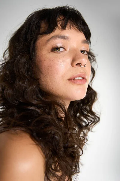 Young woman with beautiful curly hair radiates confidence and charm in her fashionable attire. — Stock Photo