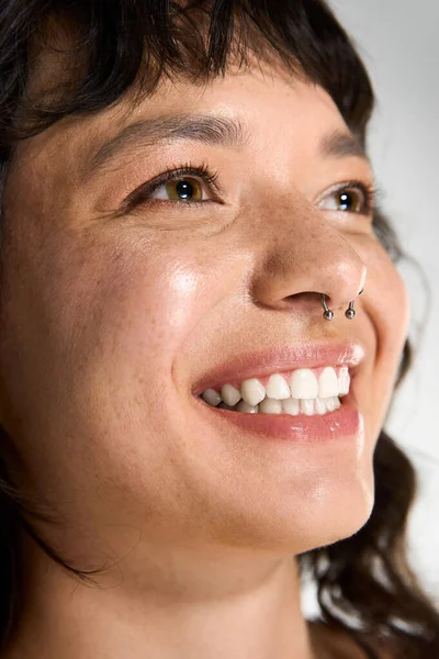 Молода жінка в модному одязі насолоджується радісним моментом, демонструючи свою сяючу посмішку. — стокове фото