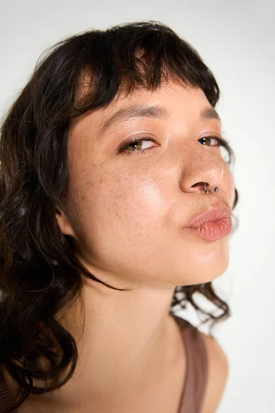 Молода жінка випромінює красу і стиль, позуючи з чарівним виразом. — стокове фото