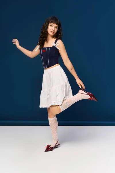 Красивая юная леди изящно танцует, одетая в стильный наряд, излучающая радость и уверенность. — стоковое фото