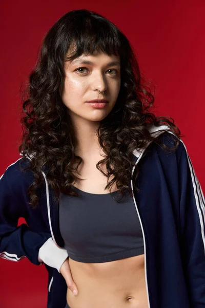 Eine schöne junge Frau zeigt ihren Sinn für Mode und steht mutig in einem farbenfrohen Rahmen. — Stockfoto