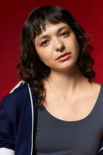 Eine junge schöne Frau posiert selbstbewusst in trendiger Kleidung, die einzigartigen Stil und Charme ausstrahlt. — Stockfoto