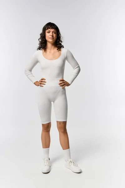 Une jeune femme confiante pose dans une tenue élégante, respirant les vibrations de la mode moderne dans un studio lumineux. — Photo de stock