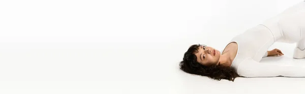 Junge schöne Frau im trendigen Outfit präsentiert ihren Stil und ihr Selbstvertrauen in einem hellen Raum. — Stockfoto