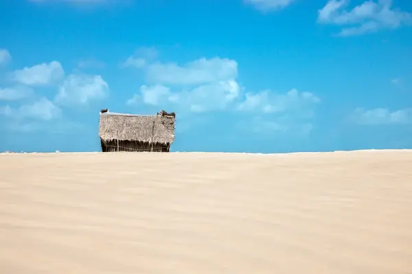 Cabaña de pescadores en la playa con arena y cielo . — Foto de Stock