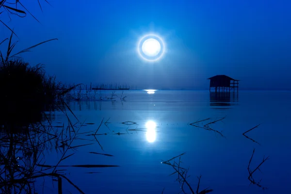 Moonset en el cielo azul en el lago., una imagen desenfocada . — Foto de Stock