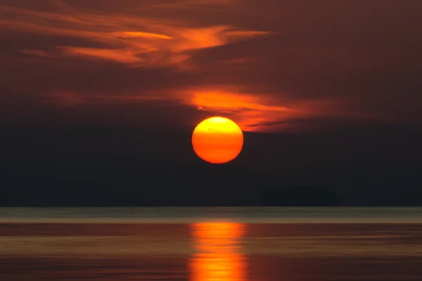 Große Sonne und orangefarbene Wolke am Abendhimmel über dem See. — Stockfoto