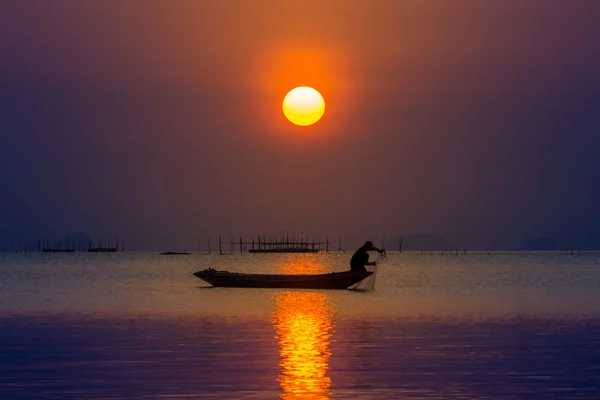 Pescador silhueta e céu pôr do sol no lago no sul da Tailândia — Fotografia de Stock
