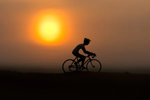 Silhouetten Radfahrer am Strand bei Sonnenuntergang. — Stockfoto