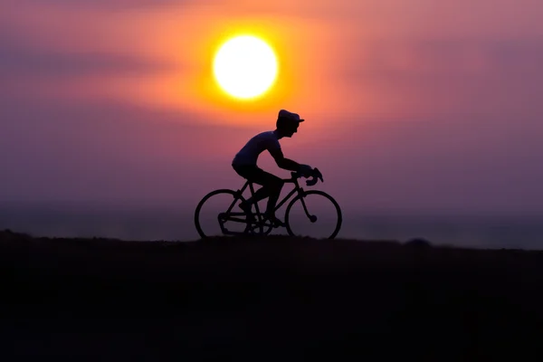 Silhouetten Radfahrer am Strand bei Sonnenuntergang. — Stockfoto