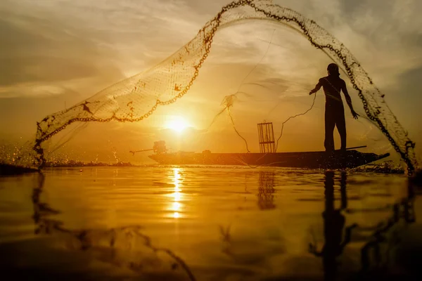 Silhouette fisherman with sunset sky on the lake. — Stock Photo, Image