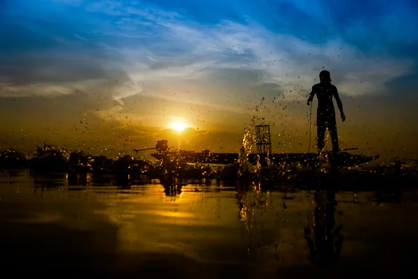 Silueta pescador con puesta de sol cielo en el lago . — Foto de Stock