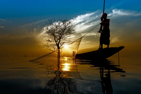 Silhouette fiskare med solnedgång himlen på sjön. — Stockfoto