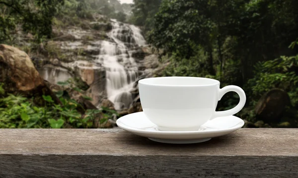 Copo de café branco no chão de madeira . — Fotografia de Stock