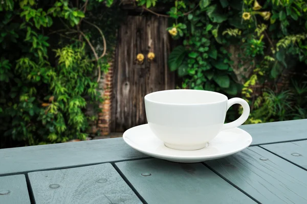 White coffee cup on table in the green park. — Stock Photo, Image