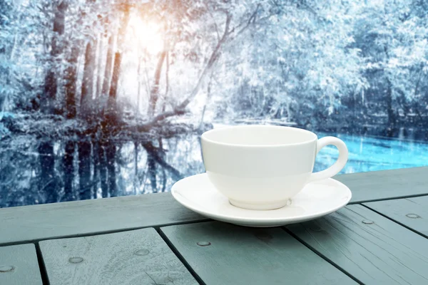Vita kaffekoppen på bordet i skogen vinter. — Stockfoto