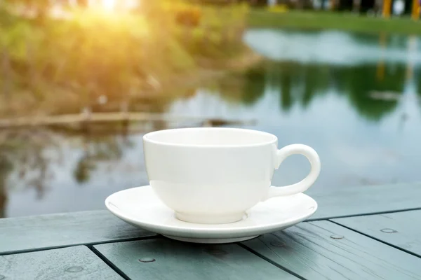 在早晨的阳光与绿色桌子上白色咖啡杯. — 图库照片