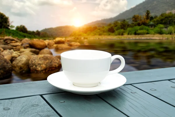 Taza de café blanco en la mesa verde por la mañana . — Foto de Stock