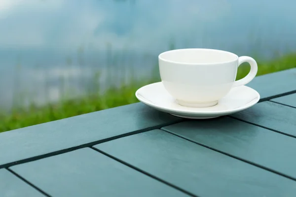 白咖啡杯子放在公园里的绿表上. — 图库照片