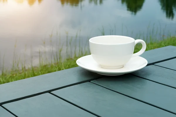 White coffee cup on green table in the park. — Stock Photo, Image