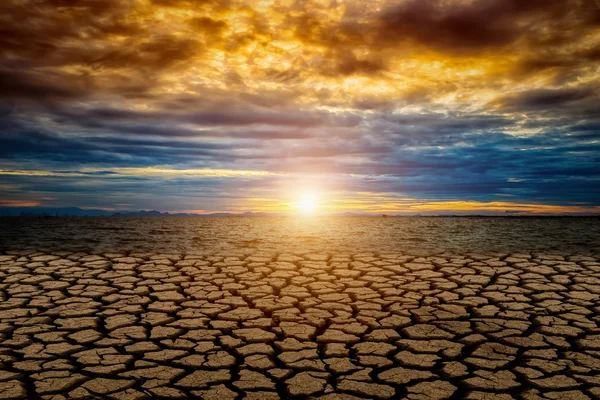 Gebarsten grond van Global warming met zonsondergang en kleur cloud. Rechtenvrije Stockfoto's