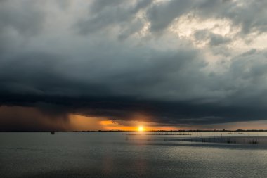 Karanlık bulutlar ve yağmur fırtınası gün batımı ile