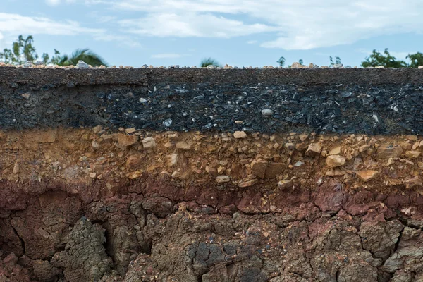 De laag van asfalt met bodem en rock. — Stockfoto