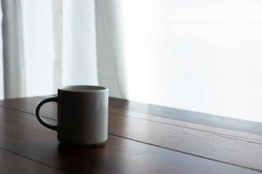 Kahve fincanı sabah sehpanın üzerinde yumuşak ışıkla..