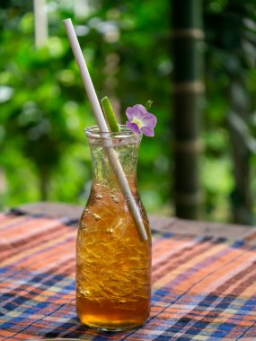 Arka planı bulanık olan buzlu çay şişesini kapat..