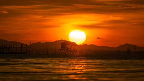 黒い湖の古い木造パビリオン。tha 夕焼け空と — ストック写真