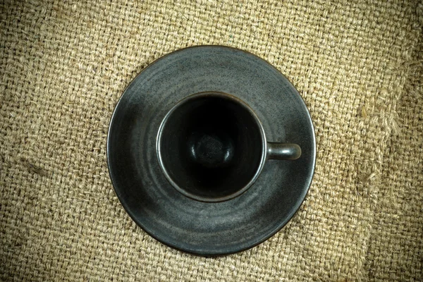 Black coffee cup on a hemp sack texture. — Stock Photo, Image