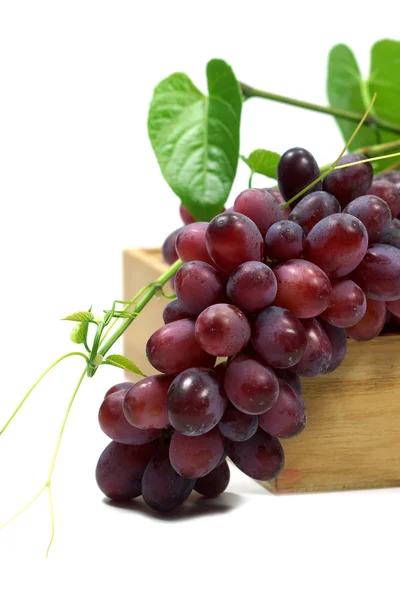 Rote Trauben in Holzkiste auf weißem Hintergrund. — Stockfoto