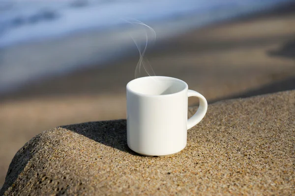 Xícara de café branco na praia . — Fotografia de Stock