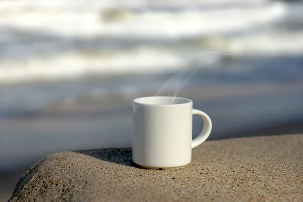 Taza de café blanco en la playa . — Foto de Stock