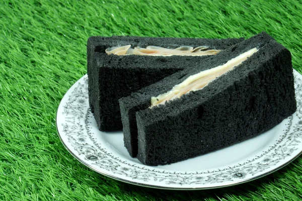 Schwarzes Sandwich mit Schinken und Käse. — Stockfoto
