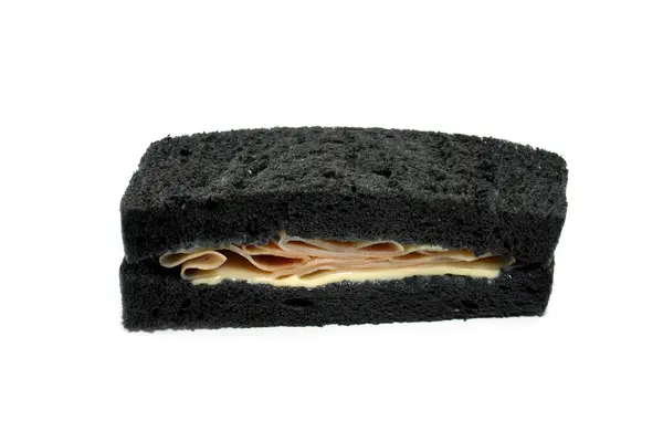 Panino nero con prosciutto e formaggio . — Foto Stock