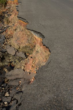 Çökmüş ve düşmüş kırık asfalt yolun kenarında