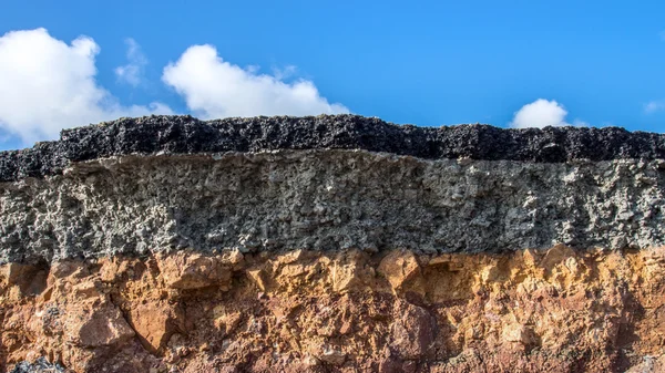 The curb erosion from storms. To indicate the layers of soil and — Stock Photo, Image