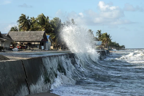 Rasande vågor till stranden, och husen av fiskarna. — Stockfoto