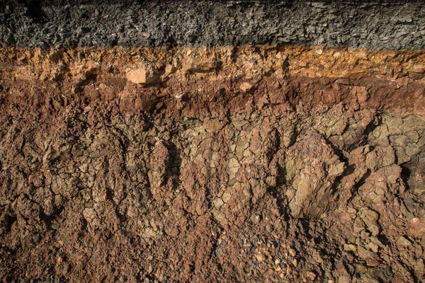 Die Erosion der Bordsteine durch Stürme. um die Bodenschichten anzuzeigen und lizenzfreie Stockbilder